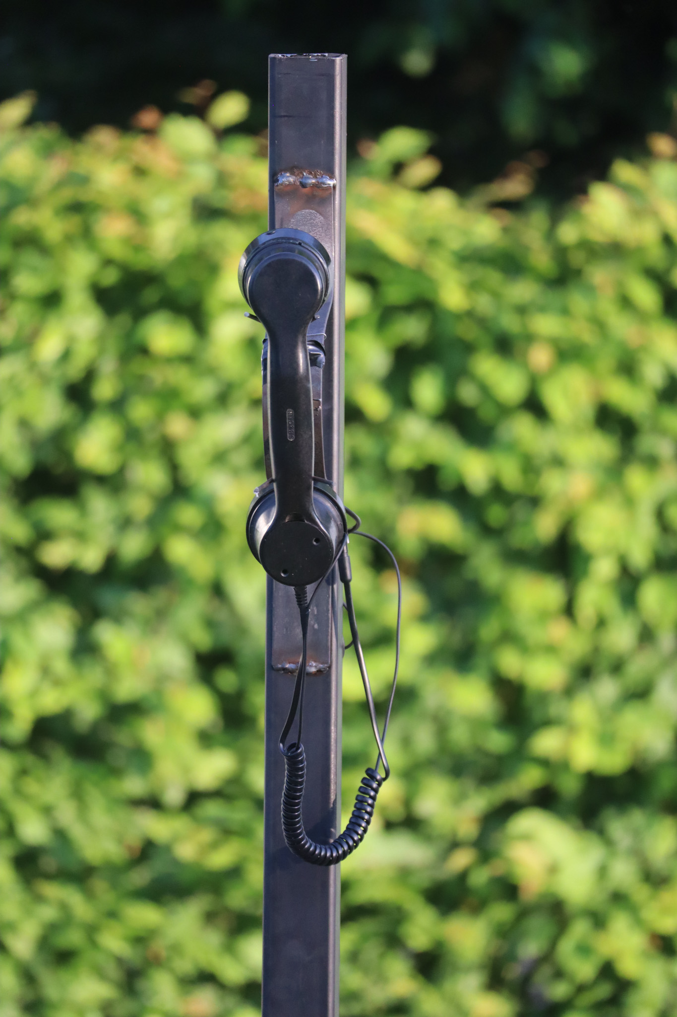 Phone on a metal pole with a red light ontop of it